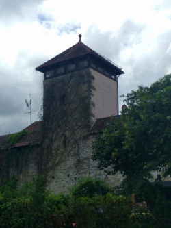 Viereckturm aus dem 13. Jahrhundert mitsamt überdachter Wehrmauer. Benannt ist der Turm nach einem seiner Bewohner.