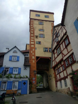 Der gelblich/beige bis organgene Torturm des Kalkweiler Tores, welcher aus dem 14. Jh. stammt.