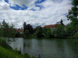 Links des Priesterseminars, bei den dunkleren Bäumen, wird der Standort der Wasserburg des Dorfes Rotenburg angenommen.